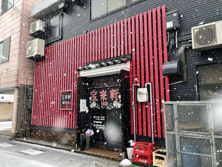 雪が舞う宝来軒総本店の外観