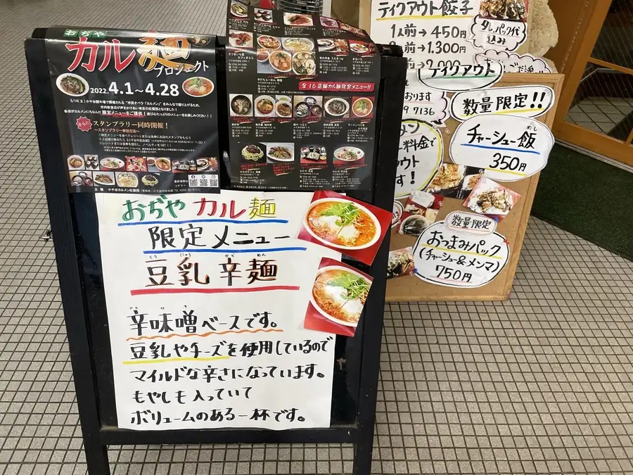 ラーメンつり吉のおぢやカル麺プロジェクトメニューが書かれた店前看板